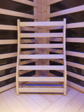 Ergonomic wooden sauna backrest made from smooth hemlock, designed for added comfort inside a traditional sauna cabin.