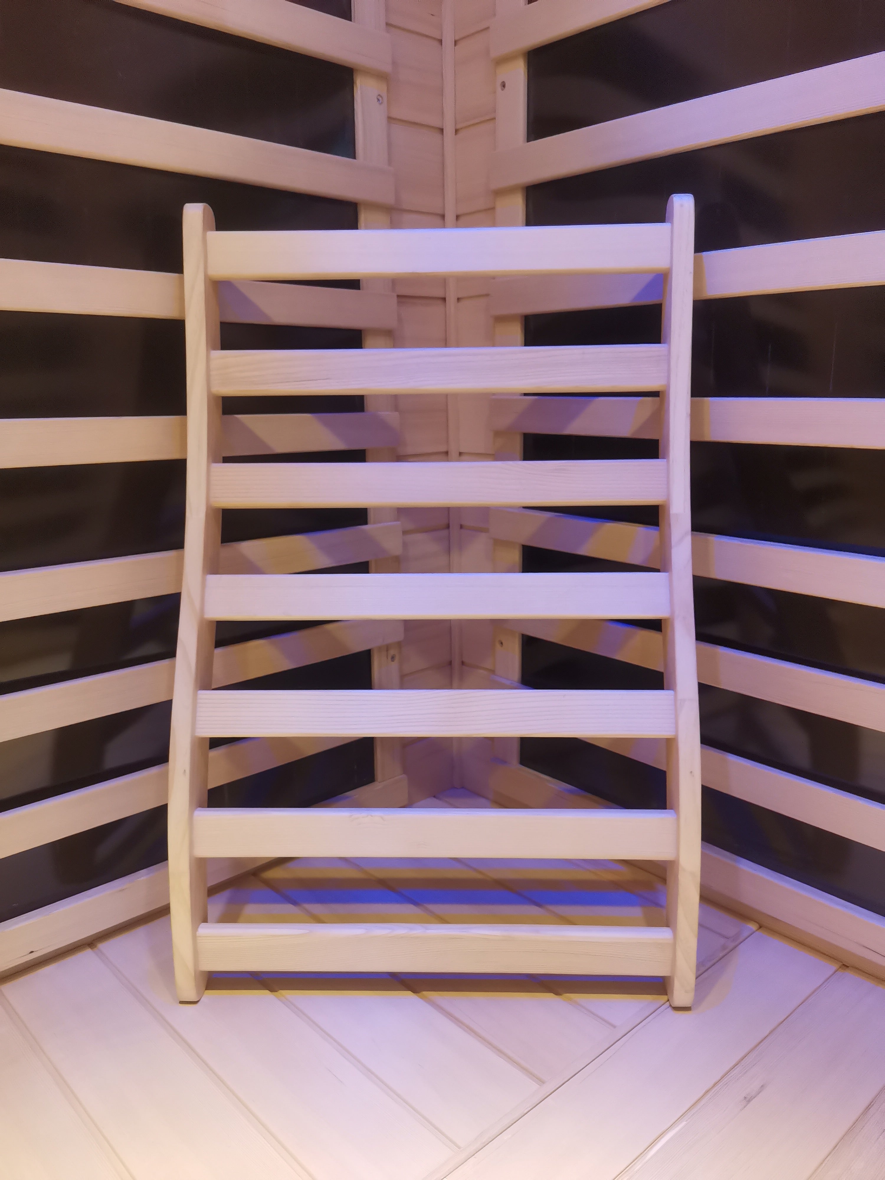 Ergonomic wooden sauna backrest made from smooth hemlock, designed for added comfort inside a traditional sauna cabin.