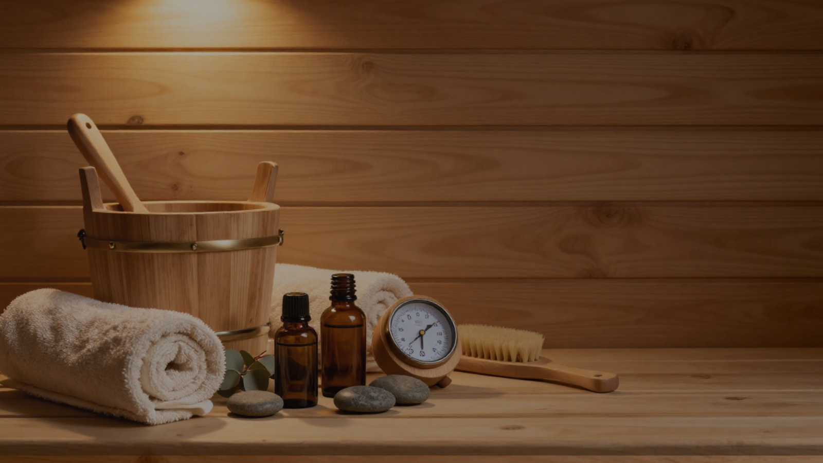 Premium sauna accessories including wood bucket, towels, oils, and wellness tools for an elevated home sauna ritual.